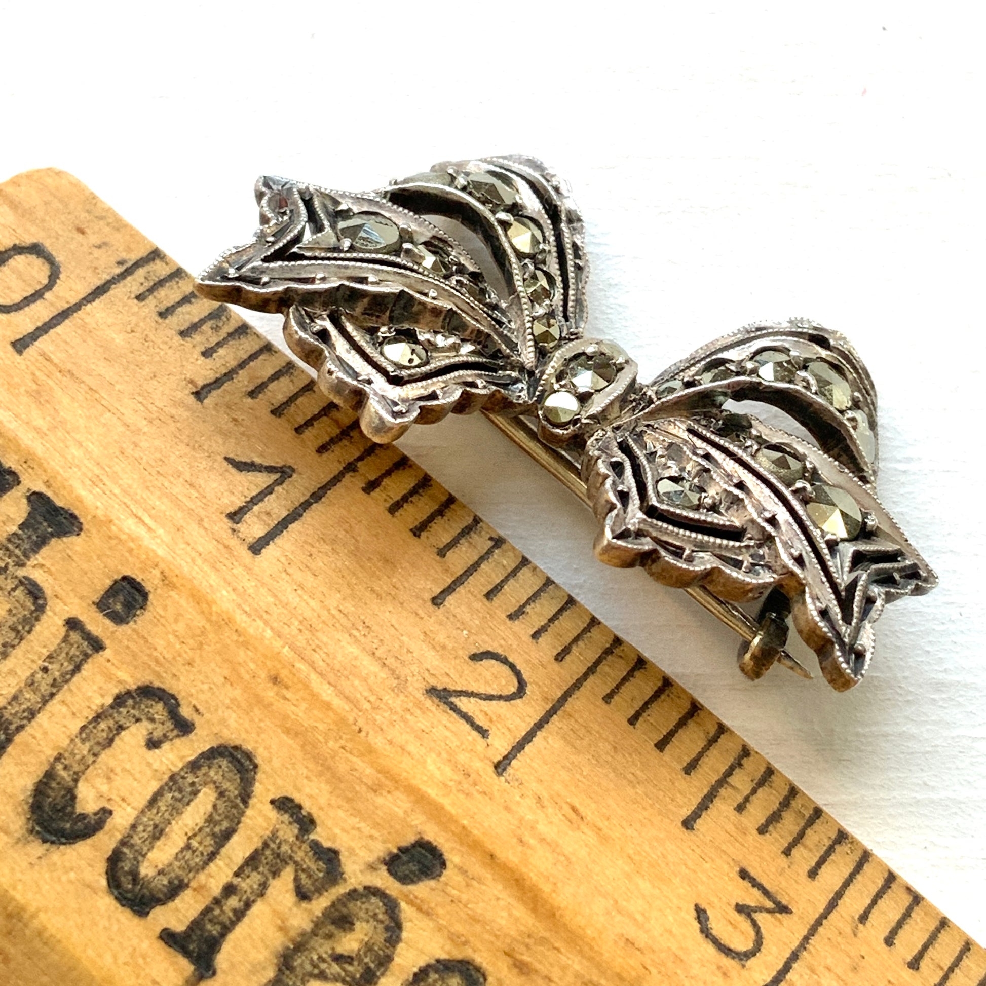A small bow brooch set with marcasites in silver. シルバーにマーカサイトがあしらわれた小さなリボンのブローチ。 