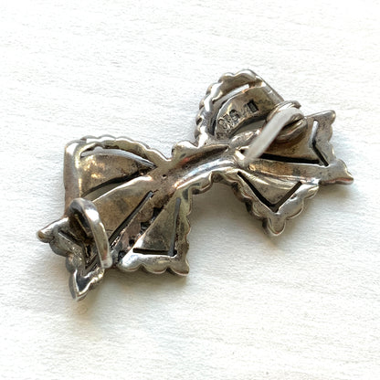 A small bow brooch set with marcasites in silver. シルバーにマーカサイトがあしらわれた小さなリボンのブローチ。 
