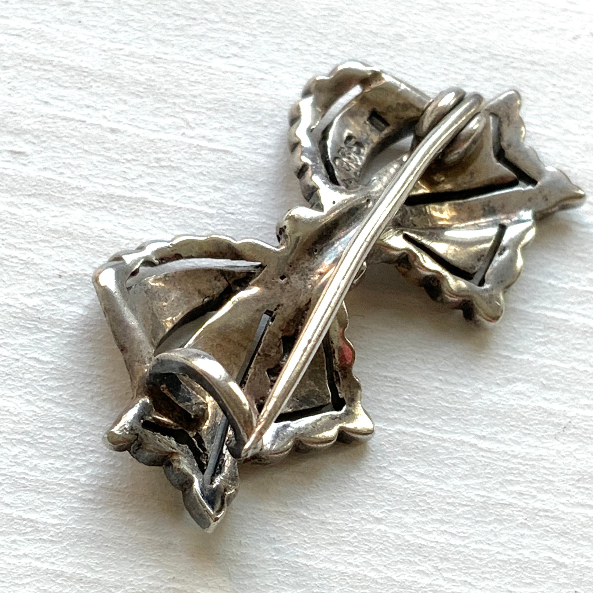 A small bow brooch set with marcasites in silver. シルバーにマーカサイトがあしらわれた小さなリボンのブローチ。 