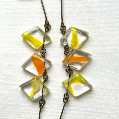Necklace featuring diamond-shaped clear glass beads infused with shades of yellow, orange, and white. クリアのダイヤ型グラスにイエロー、オレンジ、ホワイトのカラーが入ったビーズを使ったネックレス。 