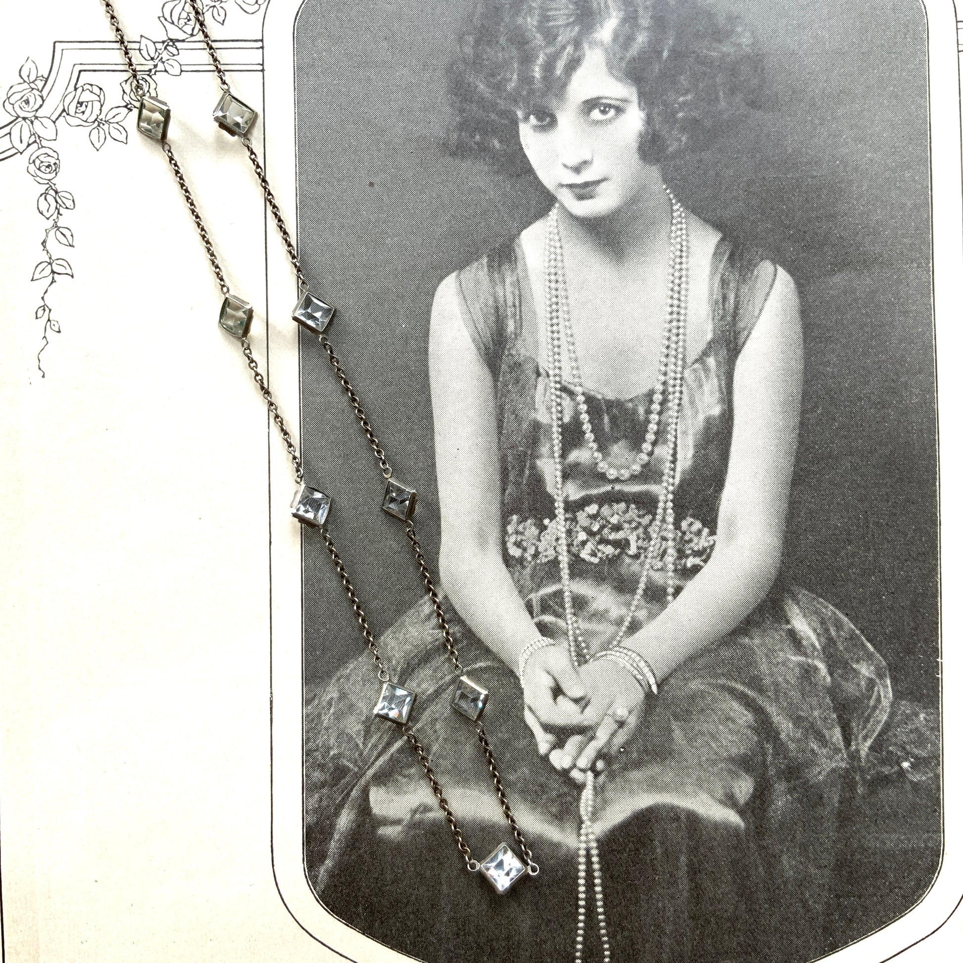 Platinon necklace set with diamond-shaped clear glass stones placed at intervals along the chain. ダイヤ型のクリアグラスがとびとびについたプラチノンのネックレス。