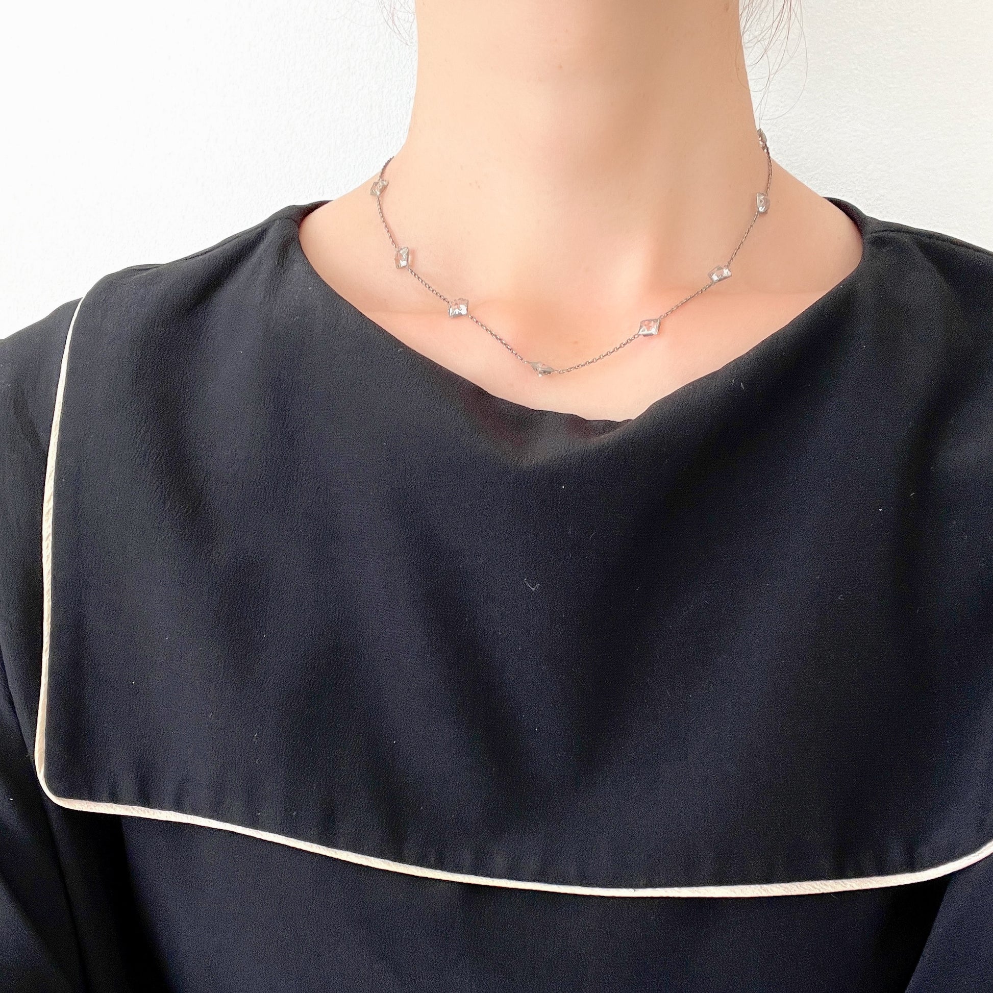 Platinon necklace set with diamond-shaped clear glass stones placed at intervals along the chain. ダイヤ型のクリアグラスがとびとびについたプラチノンのネックレス。