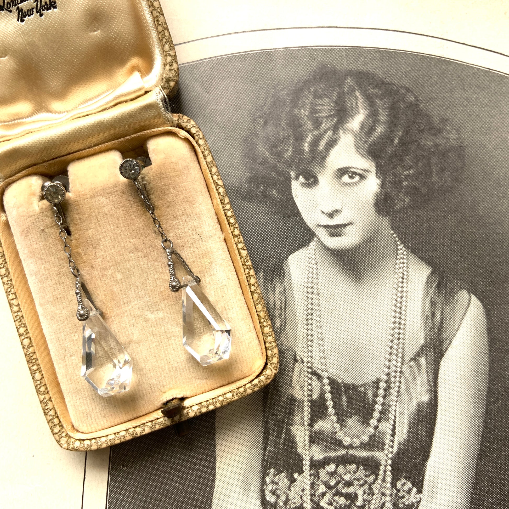 Screw-back earrings featuring clear faceted glass in a unique triangular form. ユニークな三角フォルムのファセットグラスが揺れる、スクリューイヤリング。