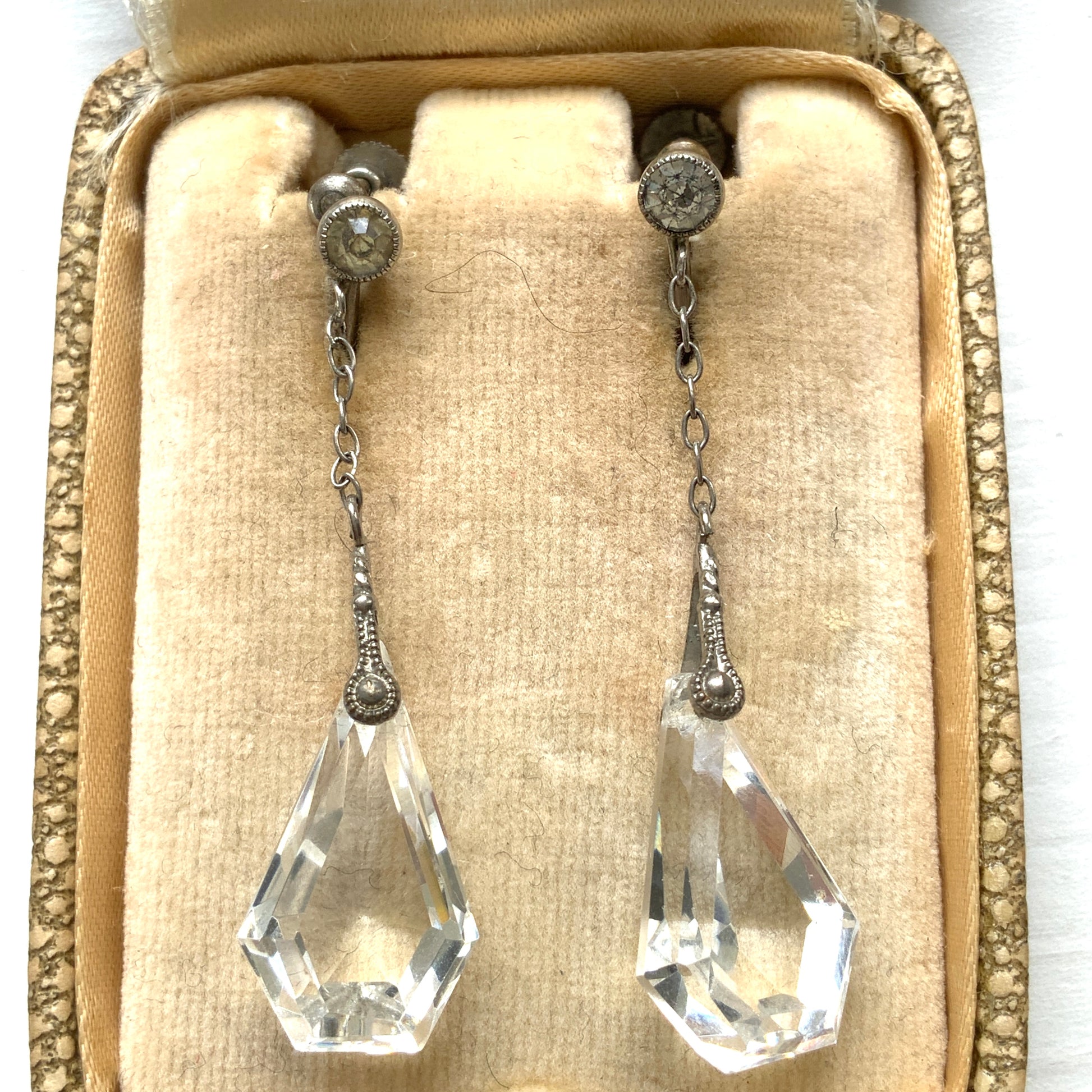 Screw-back earrings featuring clear faceted glass in a unique triangular form. ユニークな三角フォルムのファセットグラスが揺れる、スクリューイヤリング。