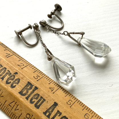 Screw-back earrings featuring clear faceted glass in a unique triangular form. ユニークな三角フォルムのファセットグラスが揺れる、スクリューイヤリング。