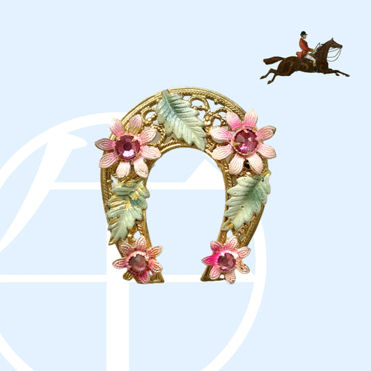 A horseshoe motif brooch adorned with pink enamel flowers. ピンクのエナメルのお花が飾られた、馬蹄モチーフのブローチ。 