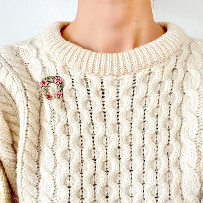 A horseshoe motif brooch adorned with pink enamel flowers. ピンクのエナメルのお花が飾られた、馬蹄モチーフのブローチ。 