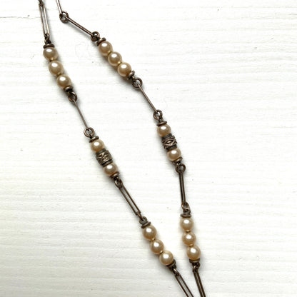 A necklace featuring metal flowers reminiscent of daisies, from which dangle chunky handmade teardrop glass pearls. デイジーのようなメタルのお花に、ゴロンとしたハンドメイドのティアドロップグラスパールがさがったネックレス。 
