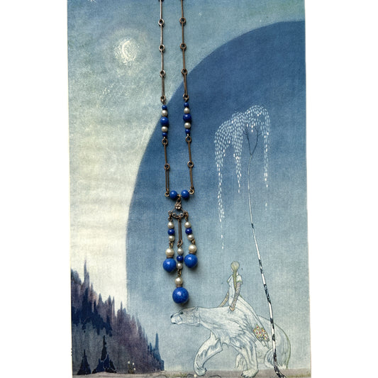 A fringe necklace featuring alternating small blue mottled glass beads and glass pearls.  小粒のブルー北京グラスとグラスパールが交互に連なってフリンジになったネックレス。