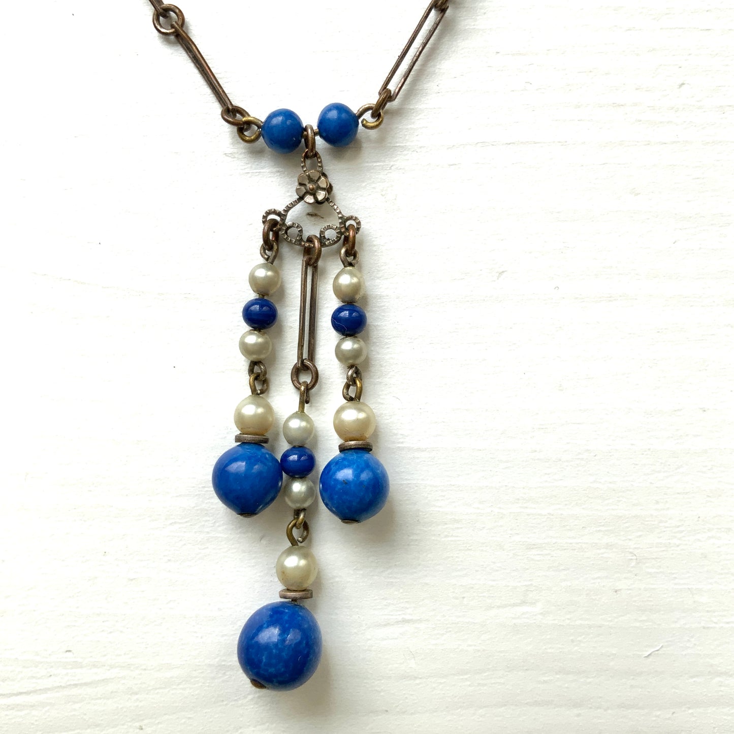 A fringe necklace featuring alternating small blue mottled glass beads and glass pearls.  小粒のブルー北京グラスとグラスパールが交互に連なってフリンジになったネックレス。