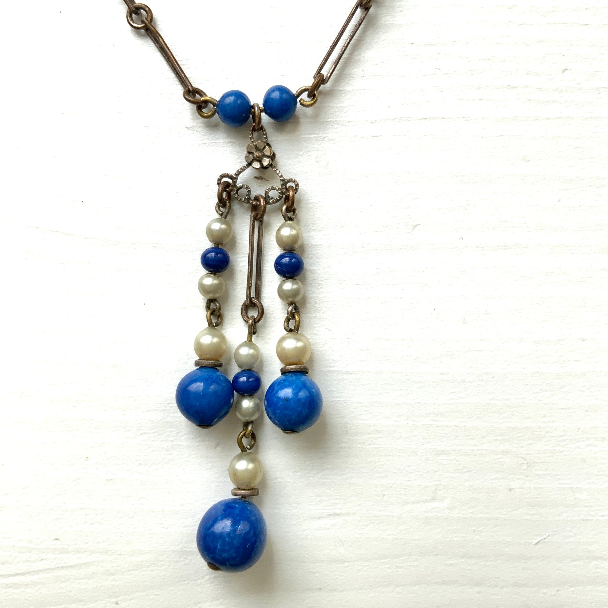A fringe necklace featuring alternating small blue mottled glass beads and glass pearls.  小粒のブルー北京グラスとグラスパールが交互に連なってフリンジになったネックレス。
