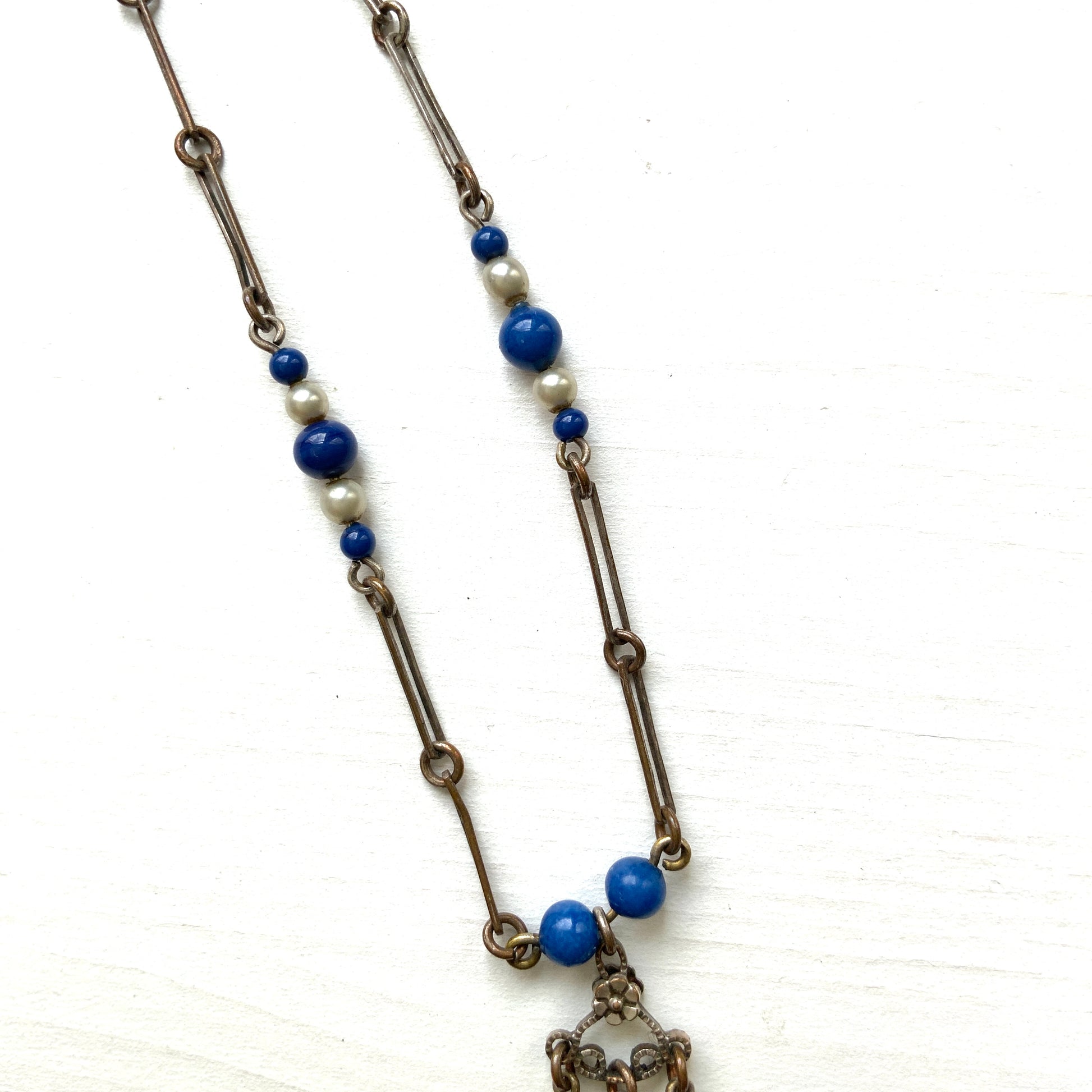 A fringe necklace featuring alternating small blue mottled glass beads and glass pearls.  小粒のブルー北京グラスとグラスパールが交互に連なってフリンジになったネックレス。