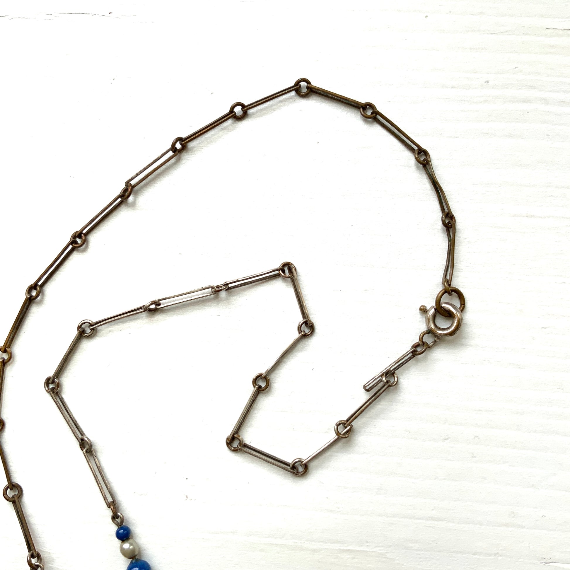 A fringe necklace featuring alternating small blue mottled glass beads and glass pearls.  小粒のブルー北京グラスとグラスパールが交互に連なってフリンジになったネックレス。