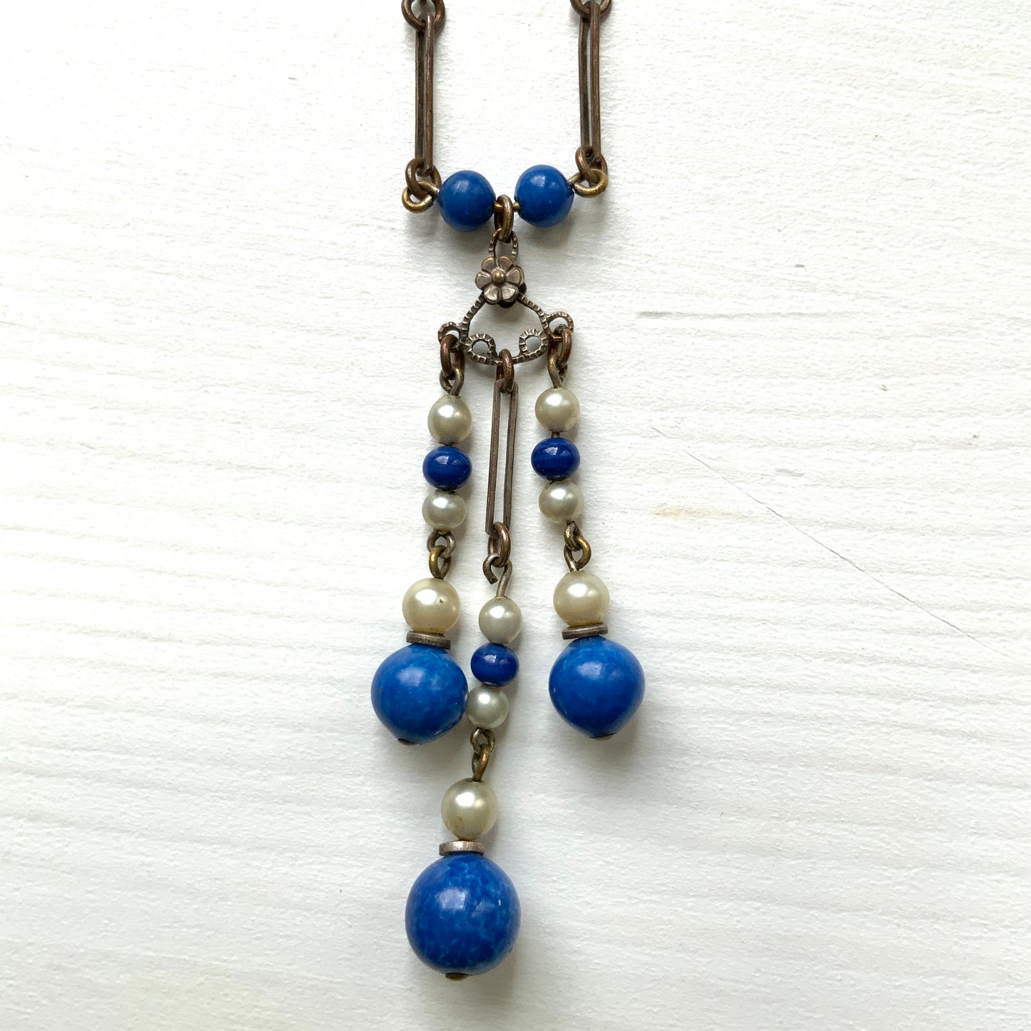 A fringe necklace featuring alternating small blue mottled glass beads and glass pearls.  小粒のブルー北京グラスとグラスパールが交互に連なってフリンジになったネックレス。