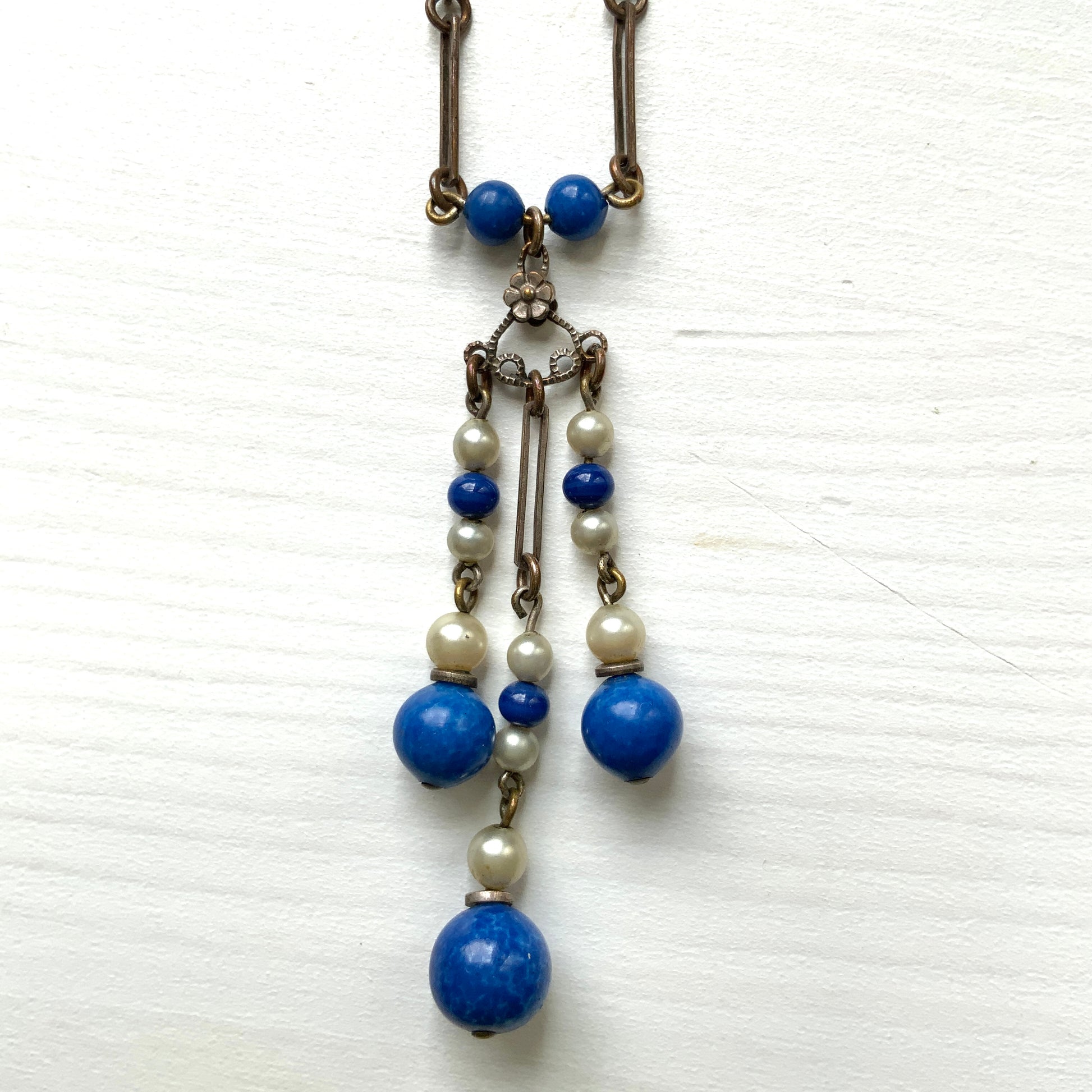 A fringe necklace featuring alternating small blue mottled glass beads and glass pearls.  小粒のブルー北京グラスとグラスパールが交互に連なってフリンジになったネックレス。