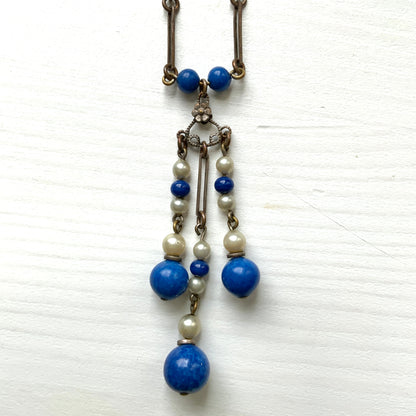 A fringe necklace featuring alternating small blue mottled glass beads and glass pearls.  小粒のブルー北京グラスとグラスパールが交互に連なってフリンジになったネックレス。
