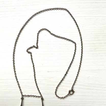 A silver necklace featuring delicate marcasite details and ivory teardrop pearls. マーカサイトの繊細なディテールとアイボリーのティアドロップパールが揺れるシルバーネックレス。