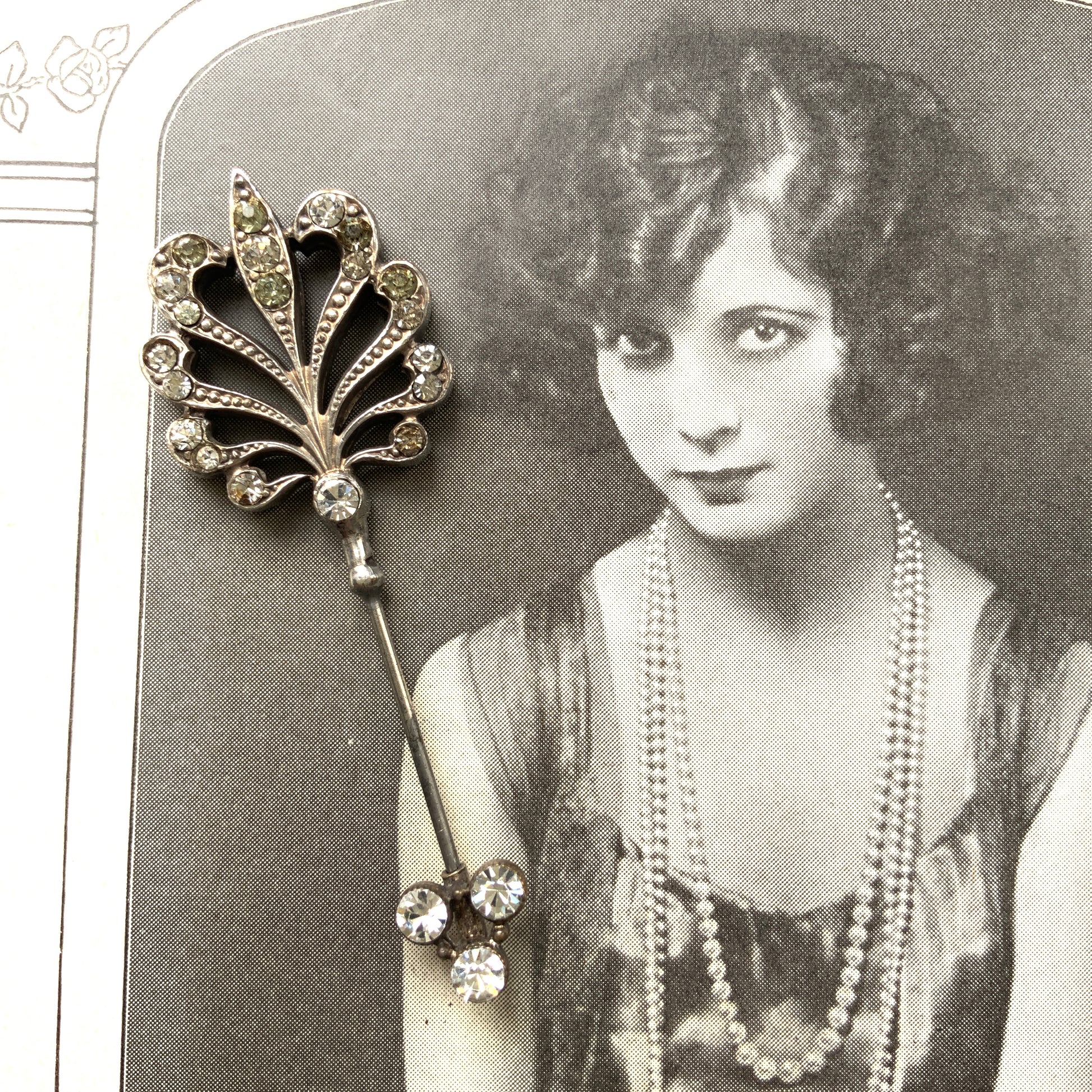 A beautiful jabot pin with a feather-like motif set with clear rhinestones. J クリアラインストーンがあしらわれた、美しい羽のようなモチーフのジャボットピン。 