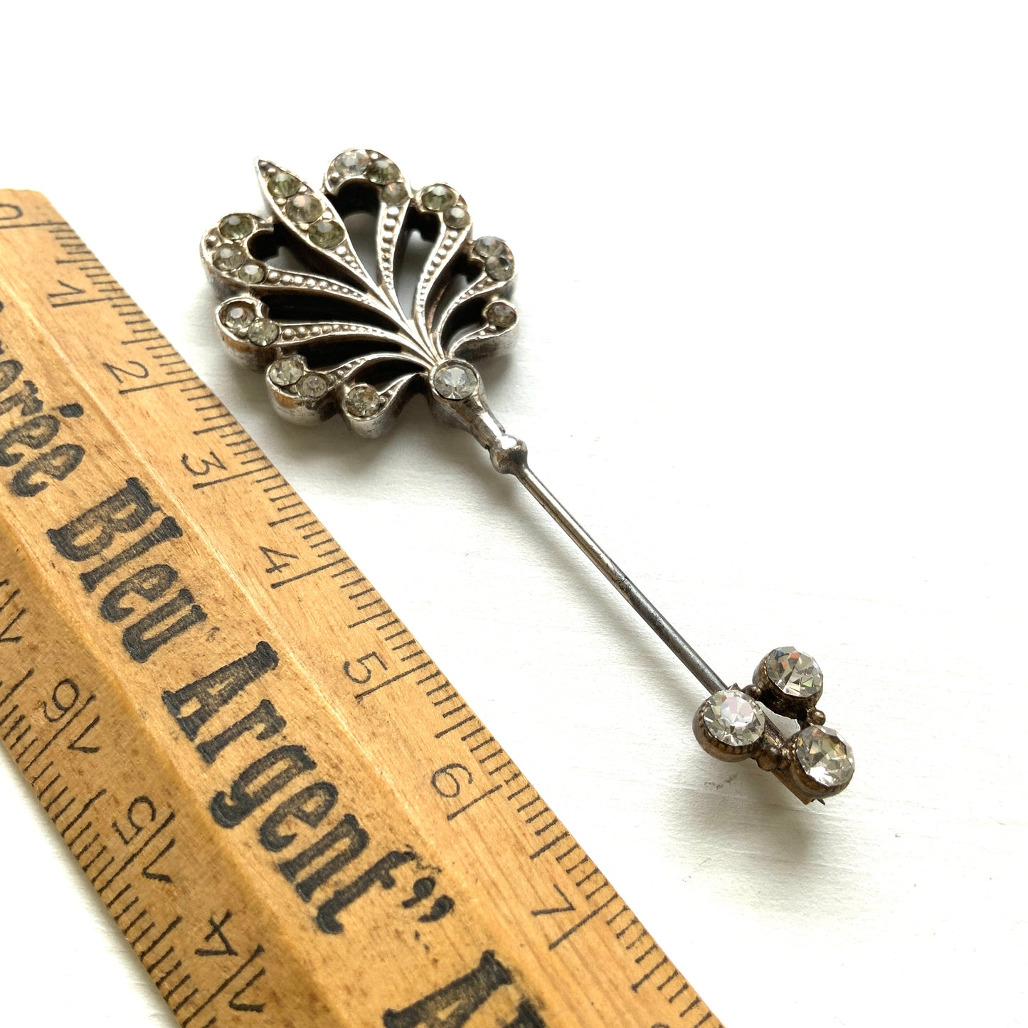 A beautiful jabot pin with a feather-like motif set with clear rhinestones. J クリアラインストーンがあしらわれた、美しい羽のようなモチーフのジャボットピン。 