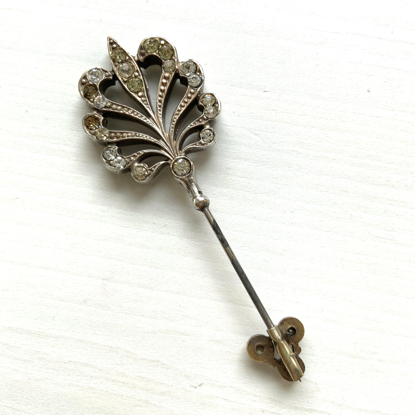 A beautiful jabot pin with a feather-like motif set with clear rhinestones. J クリアラインストーンがあしらわれた、美しい羽のようなモチーフのジャボットピン。 