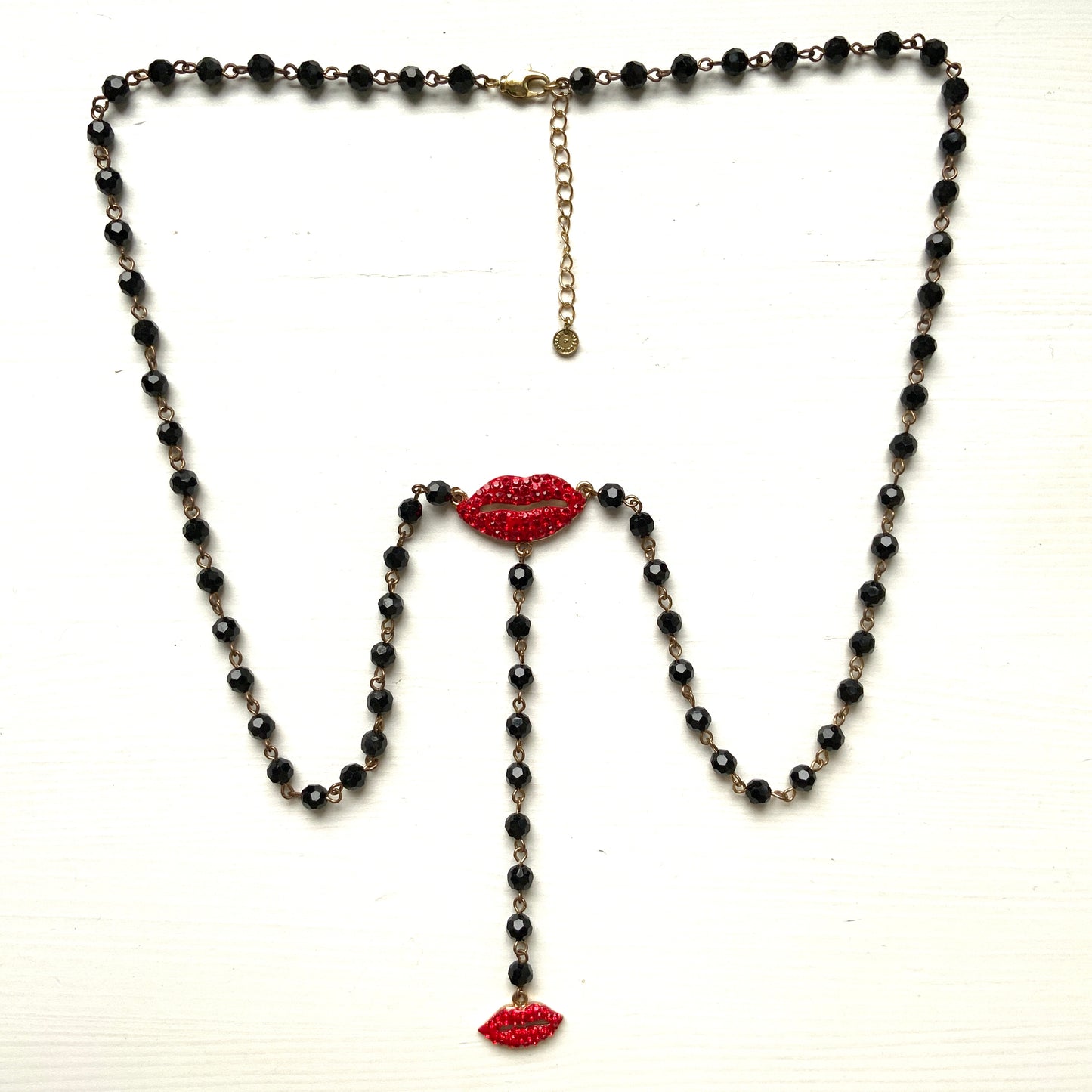 Rosary-style necklace by Butler & Wilson, featuring vivid red lips on a strand of black glass beads.  ブラックグラスビーズに真っ赤な唇をあしらった、バトラー＆ウィルソンのロザリオネックレス。