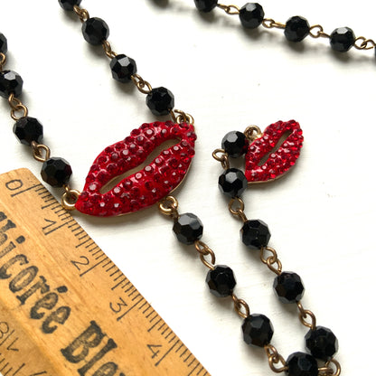 Rosary-style necklace by Butler & Wilson, featuring vivid red lips on a strand of black glass beads.  ブラックグラスビーズに真っ赤な唇をあしらった、バトラー＆ウィルソンのロザリオネックレス。