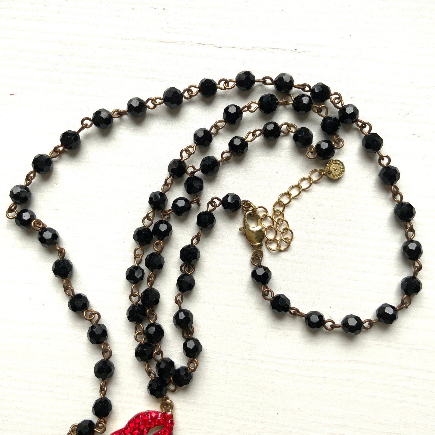 Rosary-style necklace by Butler & Wilson, featuring vivid red lips on a strand of black glass beads.  ブラックグラスビーズに真っ赤な唇をあしらった、バトラー＆ウィルソンのロザリオネックレス。