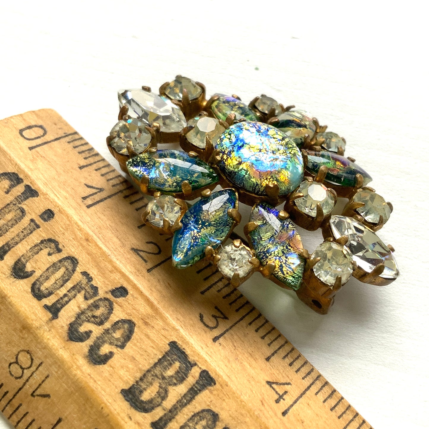 A vintage brooch featuring striking blue-toned foil glass. ブルーを基調としたフォイルグラスが印象的なヴィンテージブローチ。 