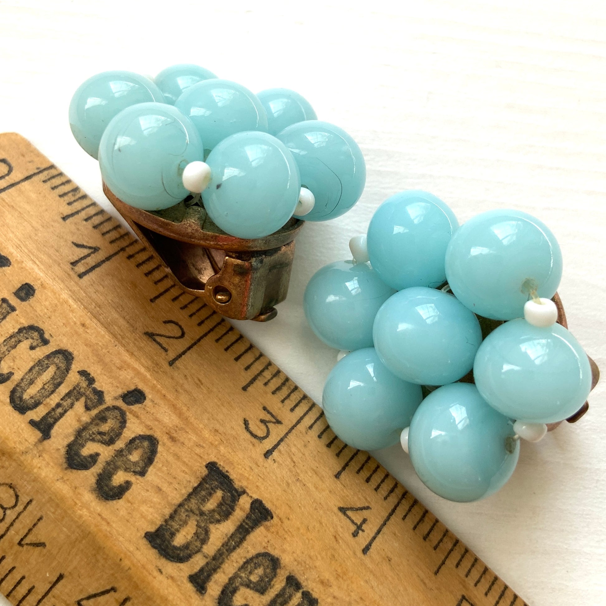 These clip-on earrings feature a cluster of soft pastel blue glass beads, accented with small milk glass beads nestled in between. 淡いパステルブルーのガラスビーズが集まったクリップイヤリング。