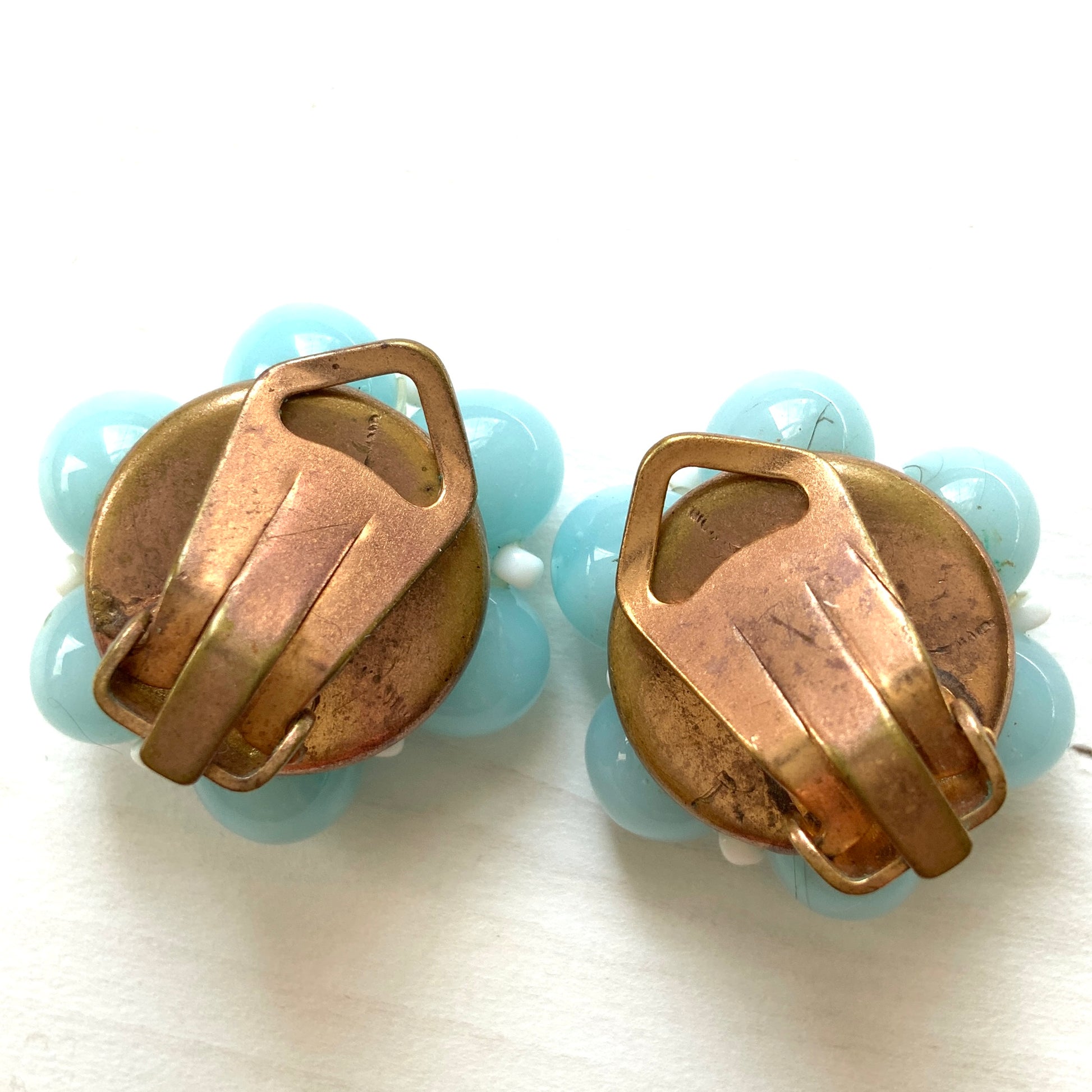 These clip-on earrings feature a cluster of soft pastel blue glass beads, accented with small milk glass beads nestled in between. 淡いパステルブルーのガラスビーズが集まったクリップイヤリング。