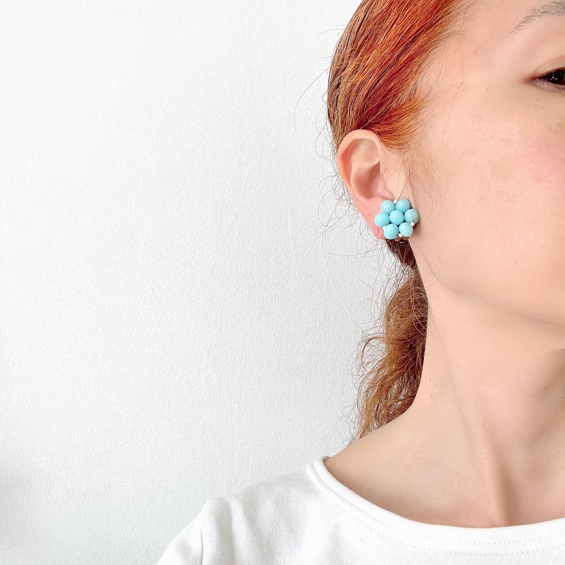 These clip-on earrings feature a cluster of soft pastel blue glass beads, accented with small milk glass beads nestled in between. 淡いパステルブルーのガラスビーズが集まったクリップイヤリング。