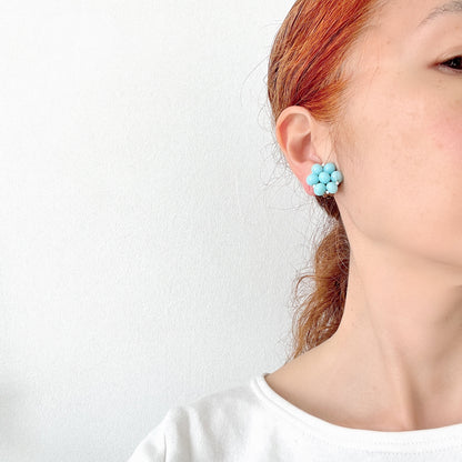 These clip-on earrings feature a cluster of soft pastel blue glass beads, accented with small milk glass beads nestled in between. 淡いパステルブルーのガラスビーズが集まったクリップイヤリング。