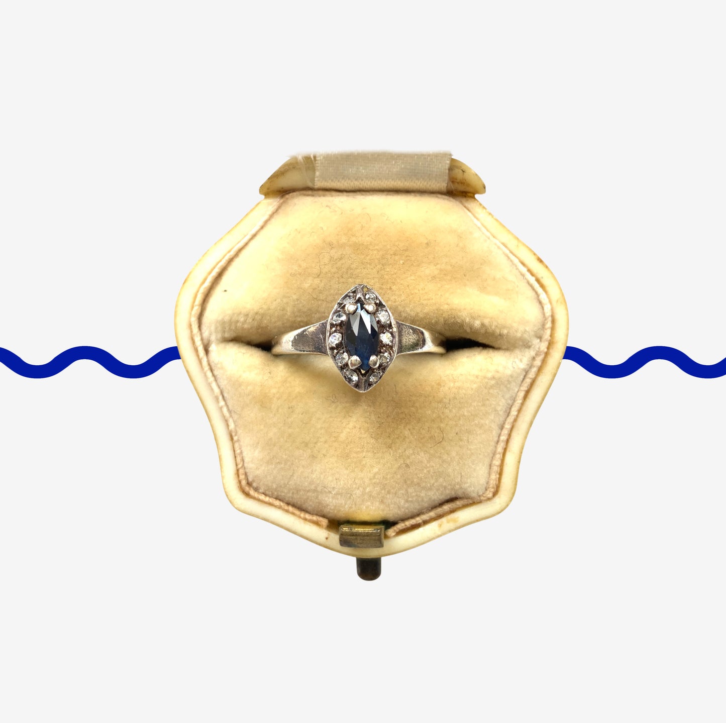 A vintage silver ring featuring a deep blue spinel reminiscent of the ocean, surrounded by delicate clear stones. 深い海のようなブルースピネルを、小さなクリアストーンで囲んだヴィンテージのシルバーリング。