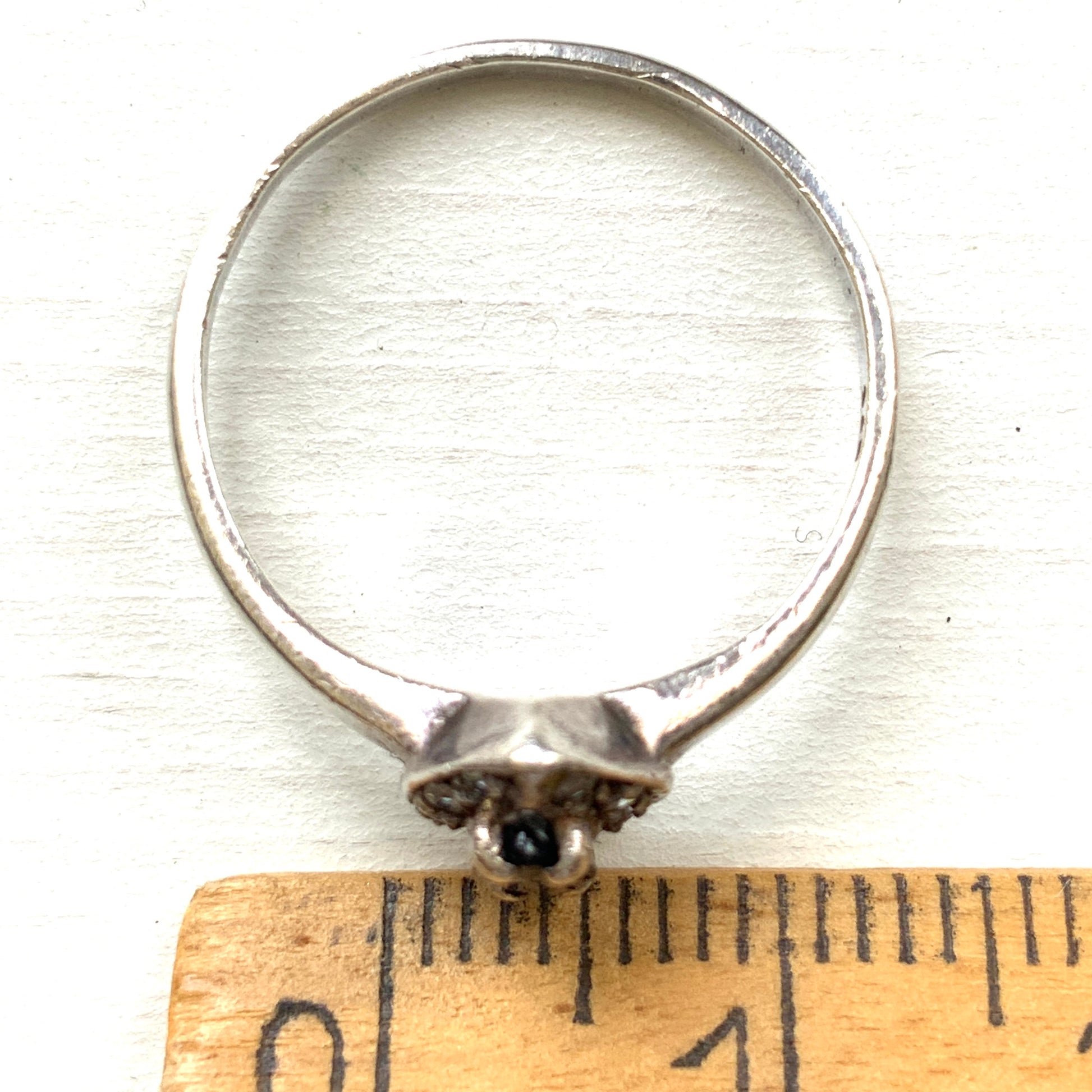 A vintage silver ring featuring a deep blue spinel reminiscent of the ocean, surrounded by delicate clear stones. 深い海のようなブルースピネルを、小さなクリアストーンで囲んだヴィンテージのシルバーリング。