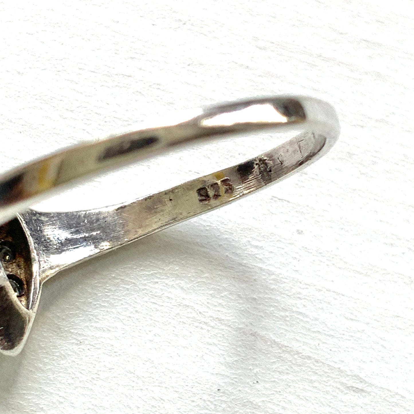 A vintage silver ring featuring a deep blue spinel reminiscent of the ocean, surrounded by delicate clear stones. 深い海のようなブルースピネルを、小さなクリアストーンで囲んだヴィンテージのシルバーリング。