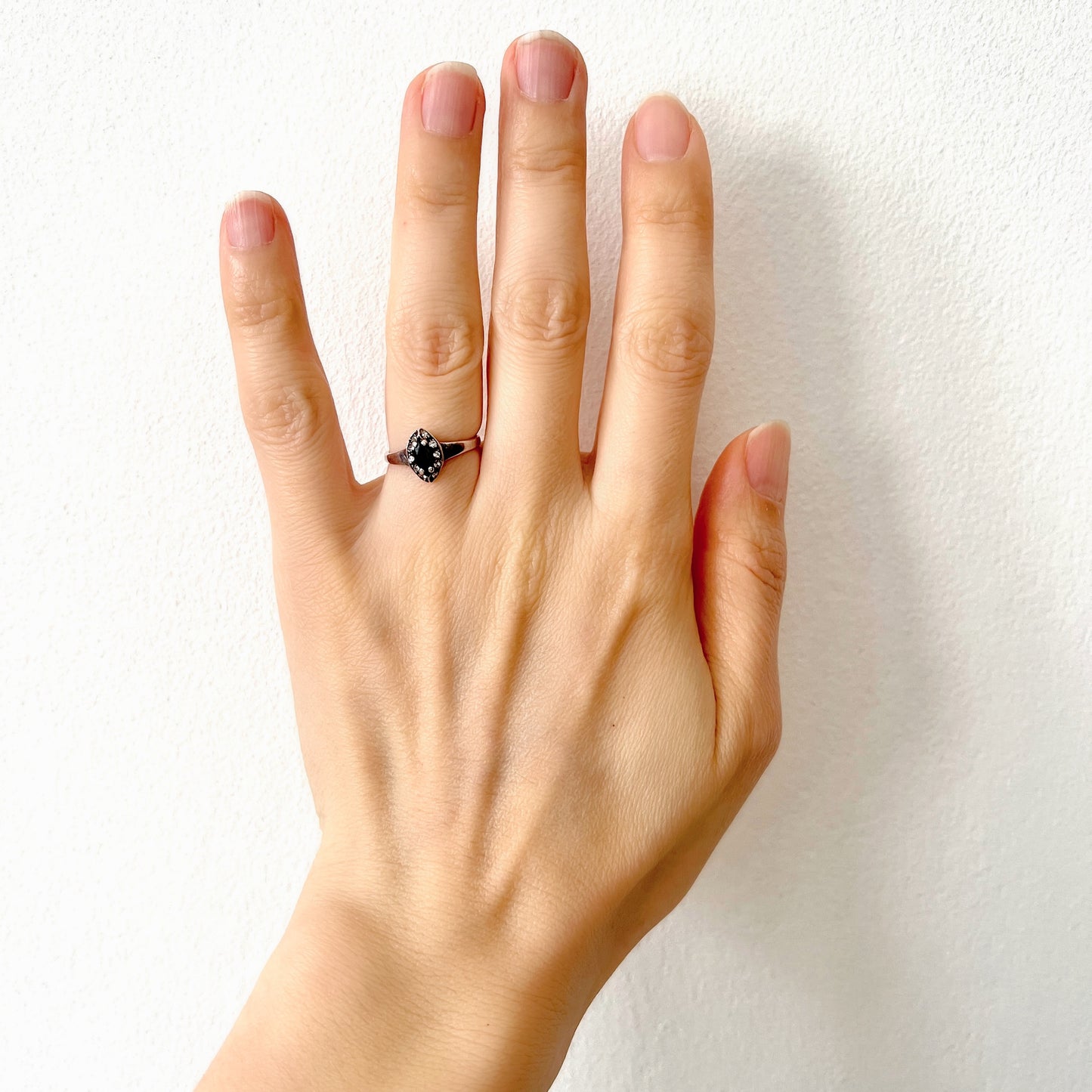 A vintage silver ring featuring a deep blue spinel reminiscent of the ocean, surrounded by delicate clear stones. 深い海のようなブルースピネルを、小さなクリアストーンで囲んだヴィンテージのシルバーリング。