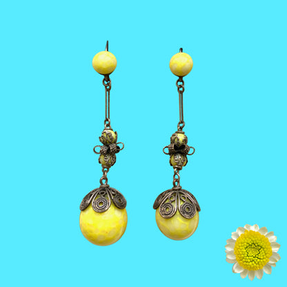 Uranium glass earrings featuring vibrant neon yellow glass beads with unique mottled patterns. 鮮やかなネオンイエローのウランガラスを使用したピアス。