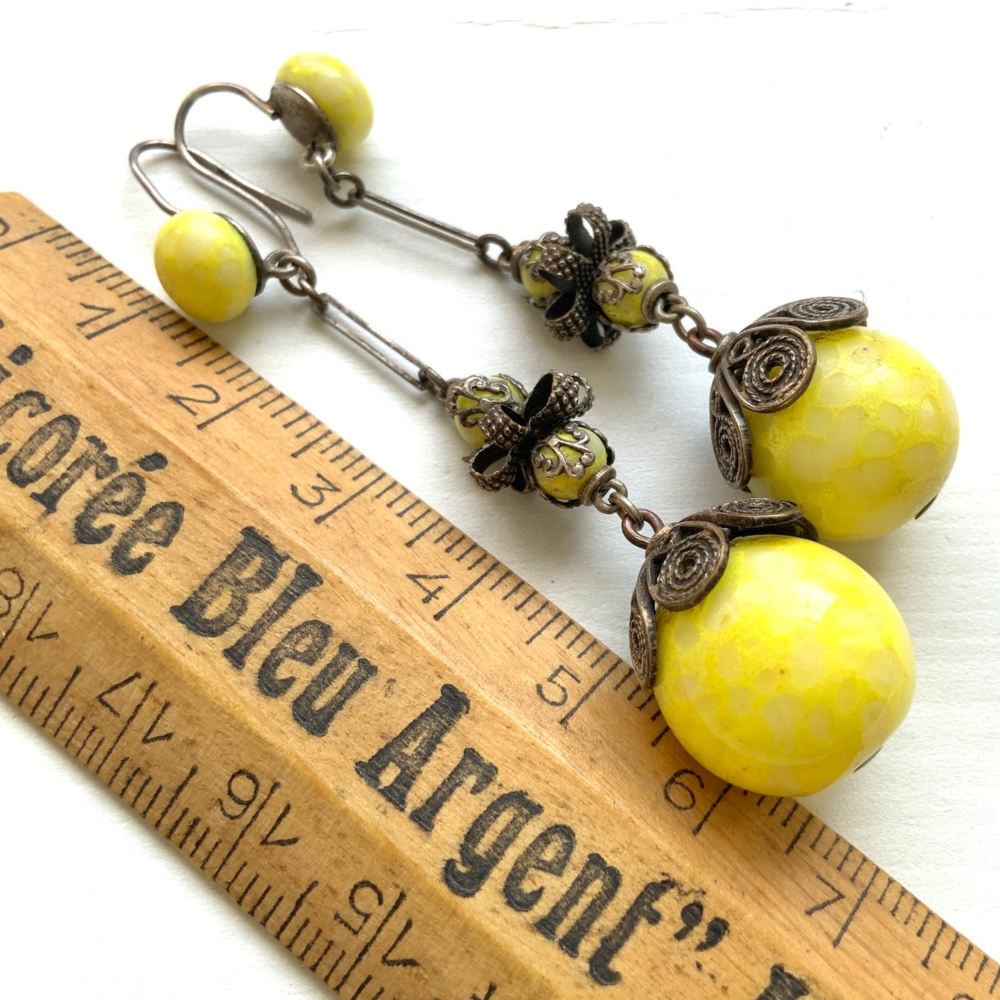 Uranium glass earrings featuring vibrant neon yellow glass beads with unique mottled patterns. 鮮やかなネオンイエローのウランガラスを使用したピアス。