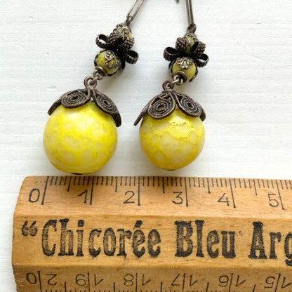 Uranium glass earrings featuring vibrant neon yellow glass beads with unique mottled patterns. 鮮やかなネオンイエローのウランガラスを使用したピアス。