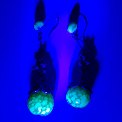 Uranium glass earrings featuring vibrant neon yellow glass beads with unique mottled patterns. 鮮やかなネオンイエローのウランガラスを使用したピアス。