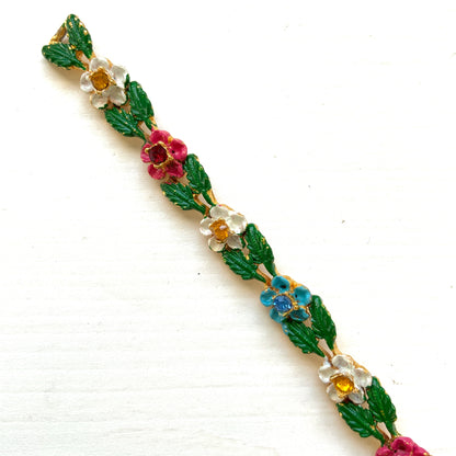 A delicate enamel bracelet adorned with rows of pink, pale blue and white flowers. ピンク、水色、白のお花が並んだエナメルのブレスレット。