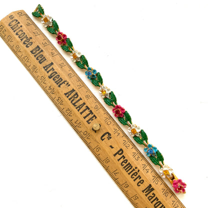 A delicate enamel bracelet adorned with rows of pink, pale blue and white flowers. ピンク、水色、白のお花が並んだエナメルのブレスレット。