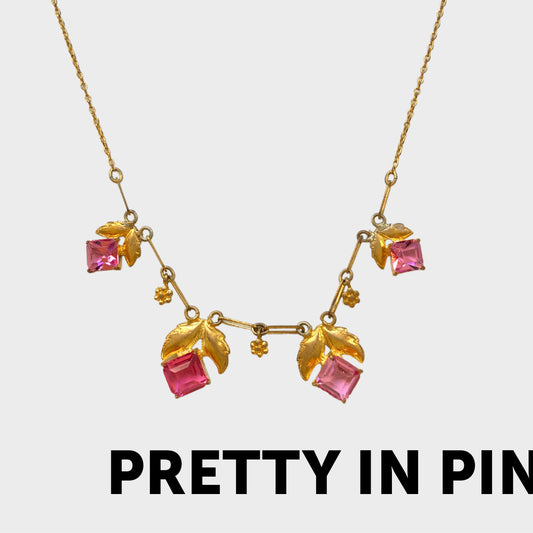 A delicate necklace featuring gold-tone leaves set with pink square glass stones. ゴールドトーンのリーフにピンクのスクエアガラスをあしらったネックレス。