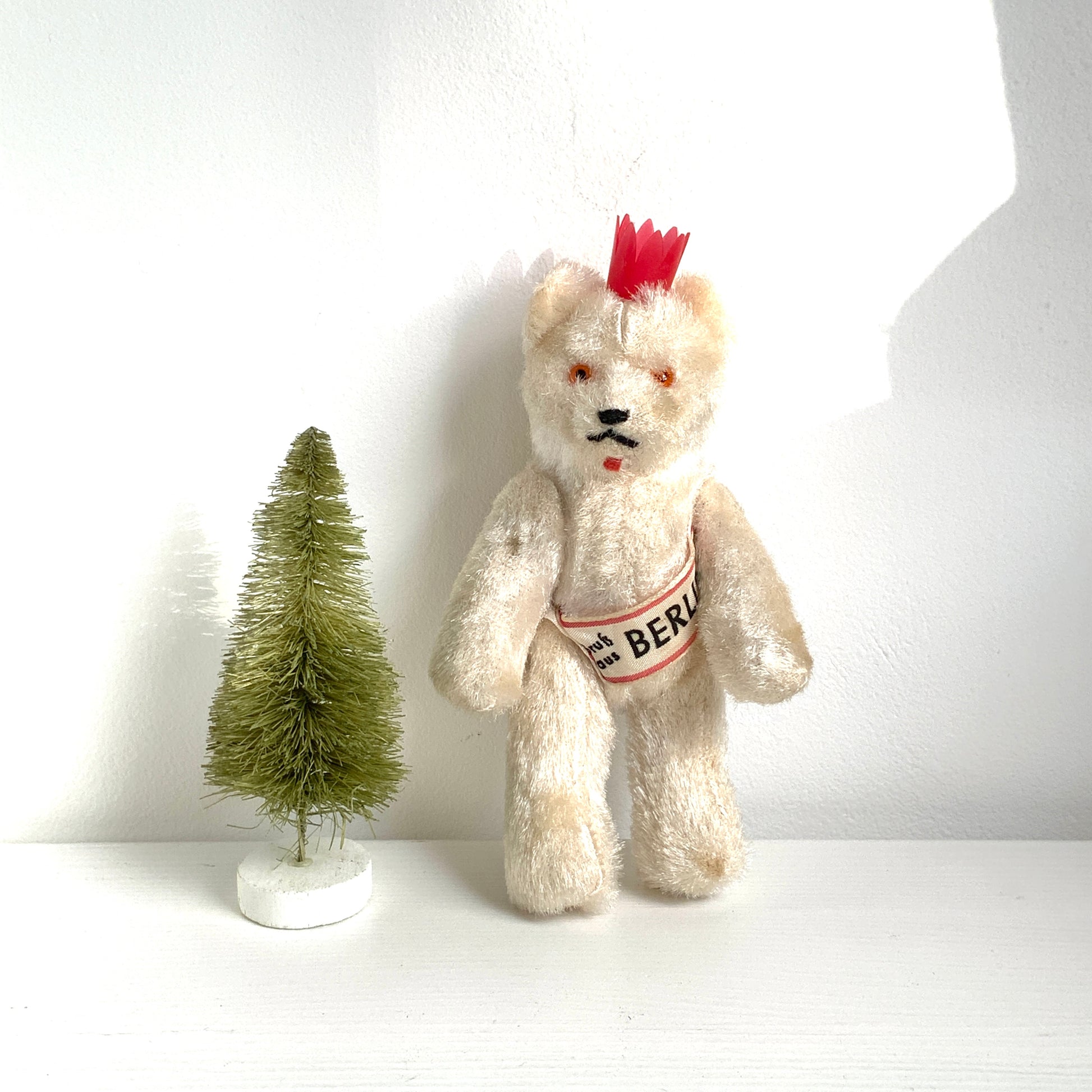 A charming white Berlin bear wearing a small red crown — a classic and recognisable Berlin souvenir.赤い王冠をかぶった、白いベルリンベアのぬいぐるみ。 定番のベルリン土産として知られるベアで、王冠とタスキが特徴的です。