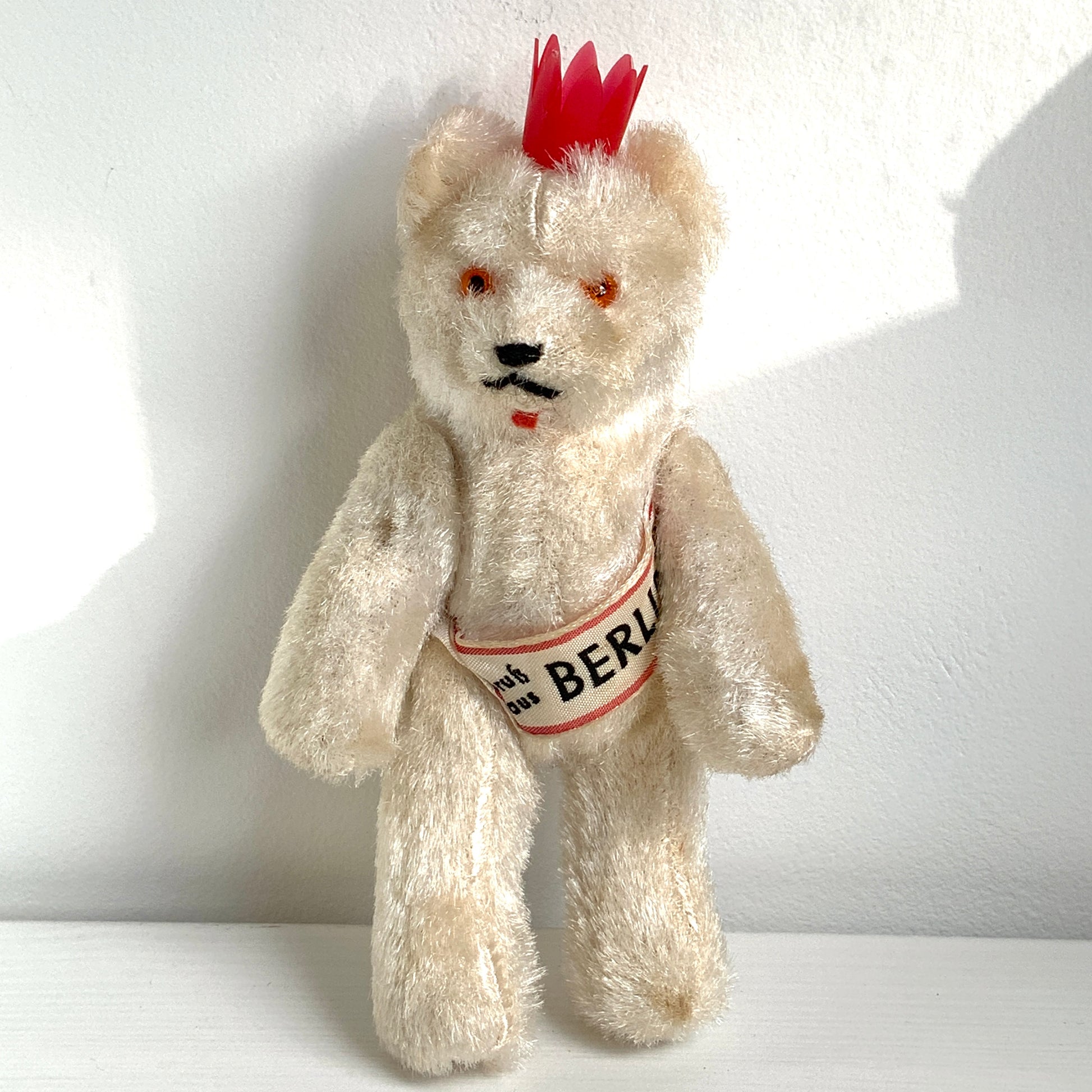 A charming white Berlin bear wearing a small red crown — a classic and recognisable Berlin souvenir.赤い王冠をかぶった、白いベルリンベアのぬいぐるみ。 定番のベルリン土産として知られるベアで、王冠とタスキが特徴的です。