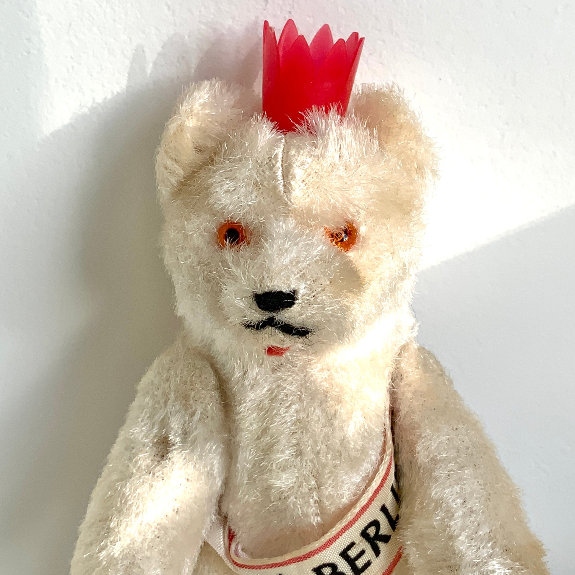 A charming white Berlin bear wearing a small red crown — a classic and recognisable Berlin souvenir.赤い王冠をかぶった、白いベルリンベアのぬいぐるみ。 定番のベルリン土産として知られるベアで、王冠とタスキが特徴的です。