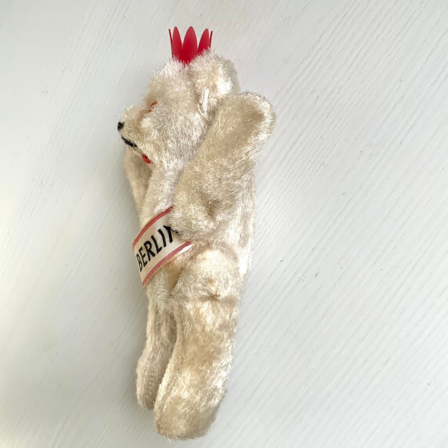 A charming white Berlin bear wearing a small red crown — a classic and recognisable Berlin souvenir.赤い王冠をかぶった、白いベルリンベアのぬいぐるみ。 定番のベルリン土産として知られるベアで、王冠とタスキが特徴的です。