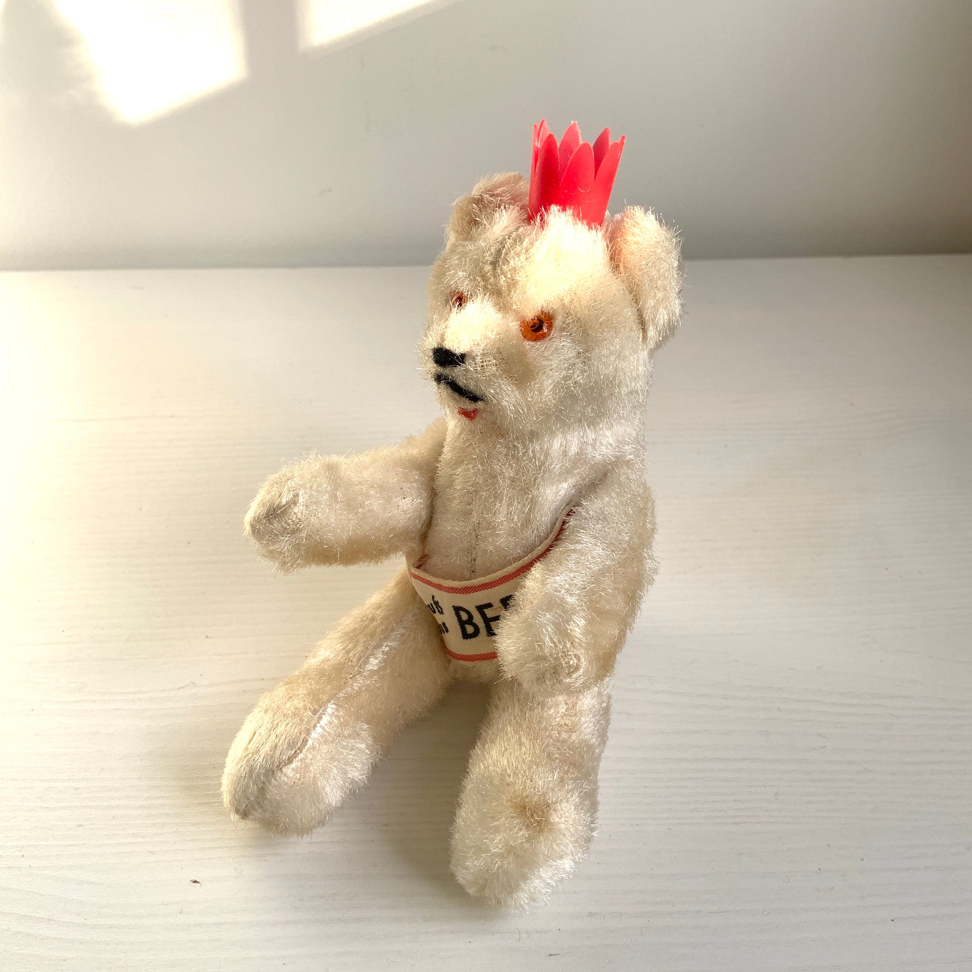 A charming white Berlin bear wearing a small red crown — a classic and recognisable Berlin souvenir.赤い王冠をかぶった、白いベルリンベアのぬいぐるみ。 定番のベルリン土産として知られるベアで、王冠とタスキが特徴的です。