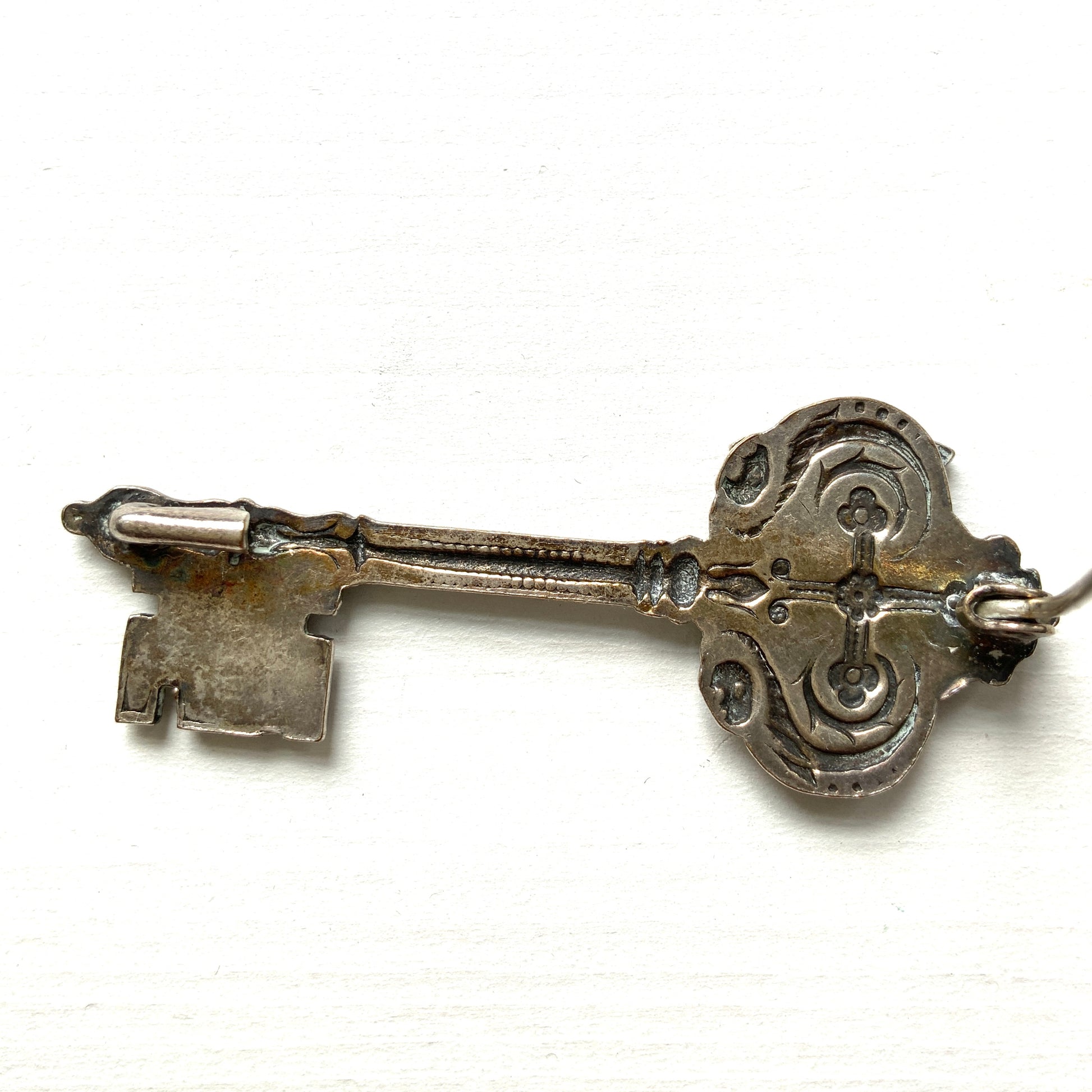 A decorative vintage key brooch featuring a crown and crest motif in a beautifully classical design. 王冠と紋章のモチーフ、クラシカルでデコラティブなデザインが素敵な鍵ブローチ。 