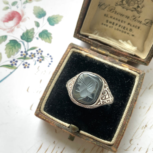 A silver ring set with dark grey, metallic hematite, intaglio-carved with the figure of a Roman warrior. ダークグレーのメタリックなヘマタイトに、ローマ時代の戦士と思われる人物像が沈み彫りされたシルバーリング。
